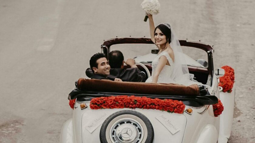 Glückliches Brautpaar in einem stilvollen Oldtimer – das perfekte Beispiel für Oldtimer mieten für Hochzeiten und besondere Anlässe